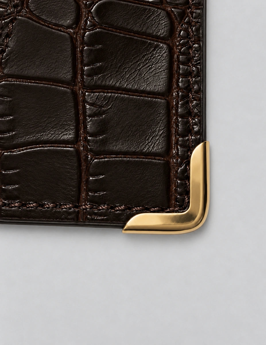 Polished gold-tone corner guard fitted around the textured card holder.
