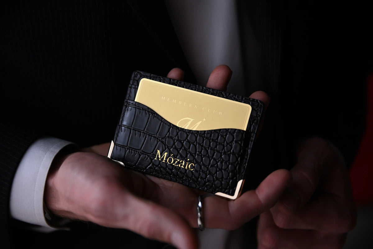 Card holder in a person’s hands with a gold Members’ Club card in its front pocket.