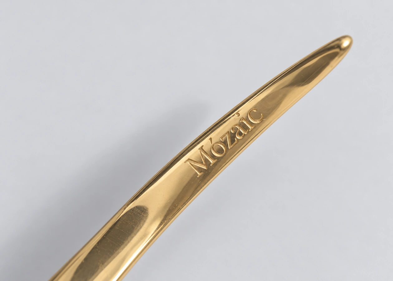 Mózaic wordmark engraved on the gold cuff.