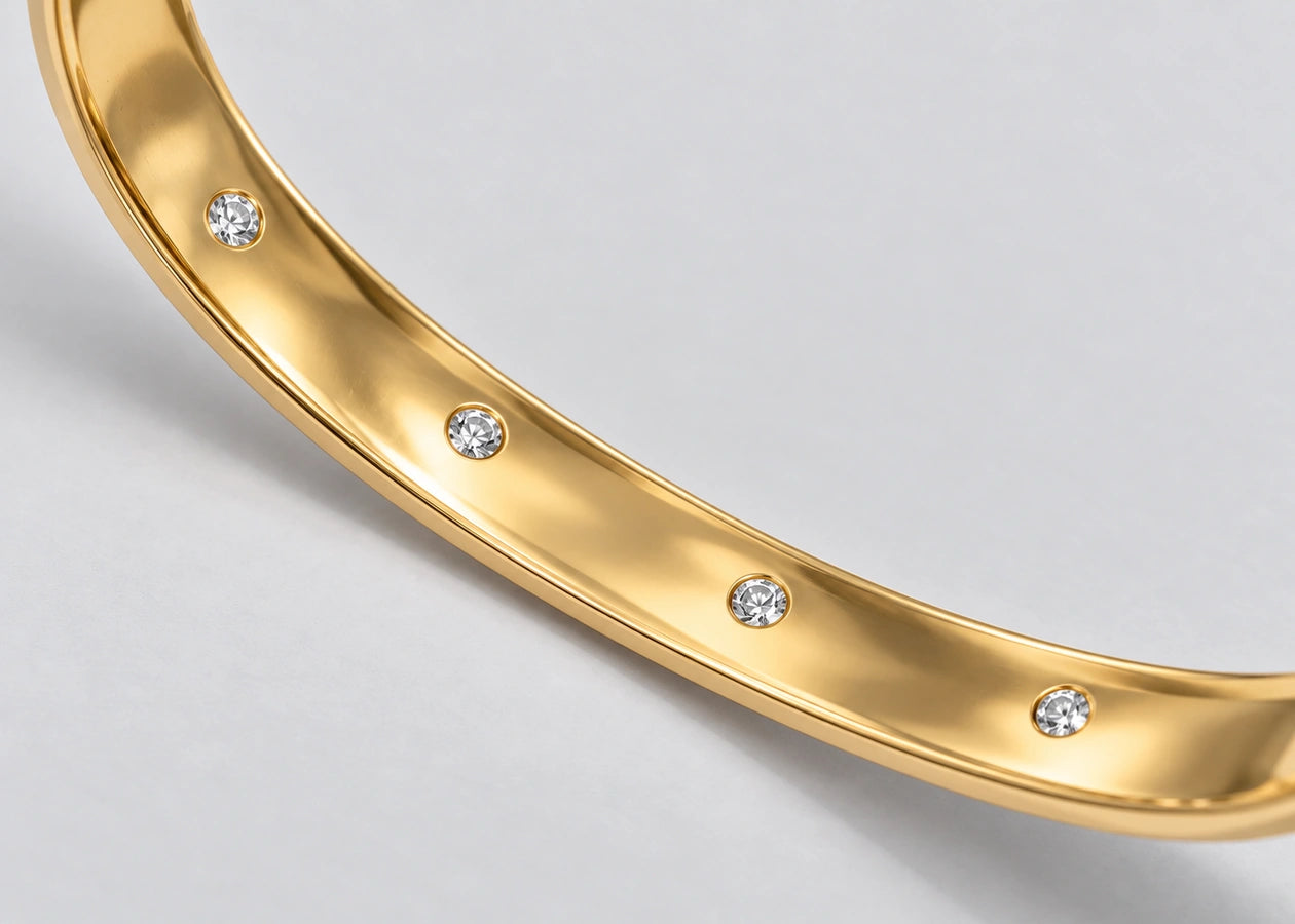 Four diamonds along the inner face of the gold cuff.