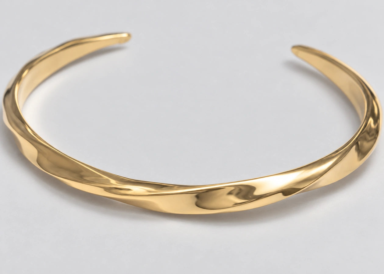 Twisting gold cuff surface with tapered ends.