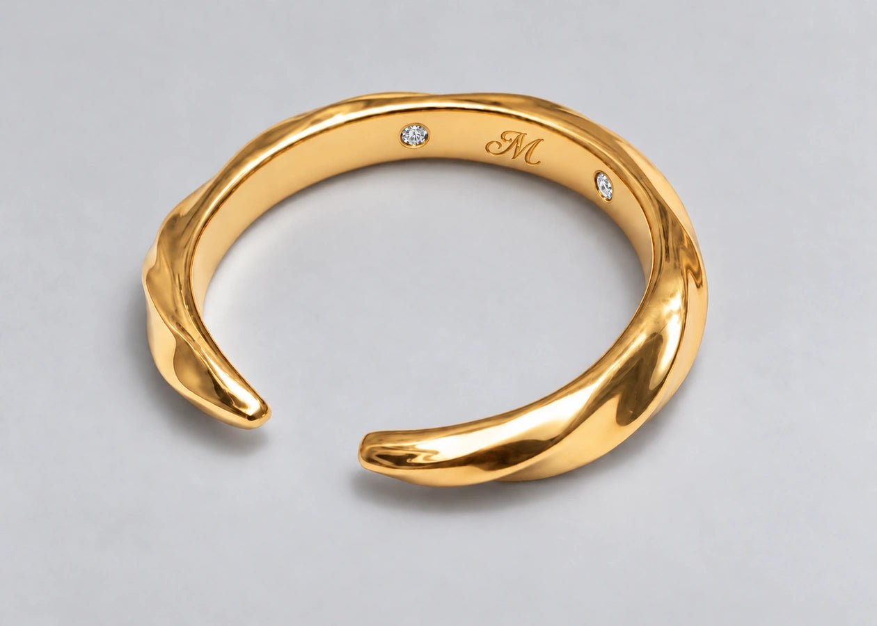 Open gold ring with its two tapered ends and inner signature visible.