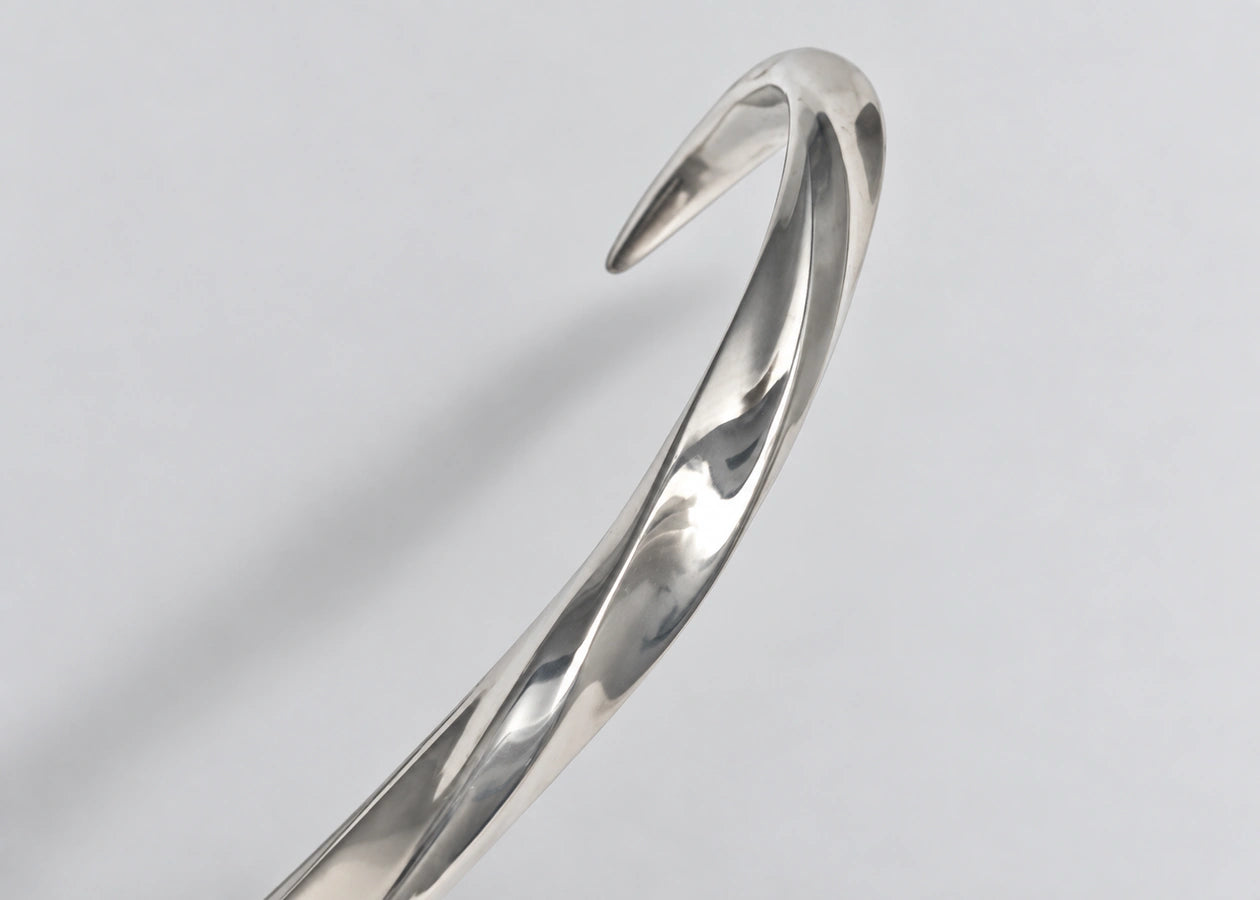 Twisting silver cuff surface and tapered end.